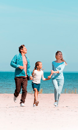 Familia en la playa volando una cometa