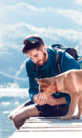 Jóven con su perro al borde del lago