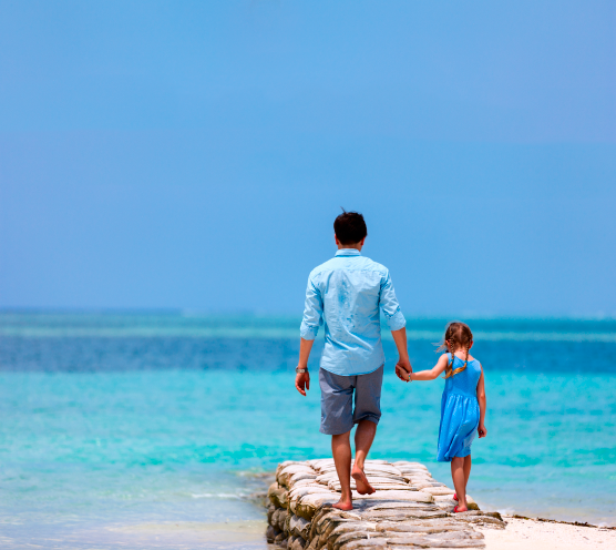 Padre de familia con su hija en la playa