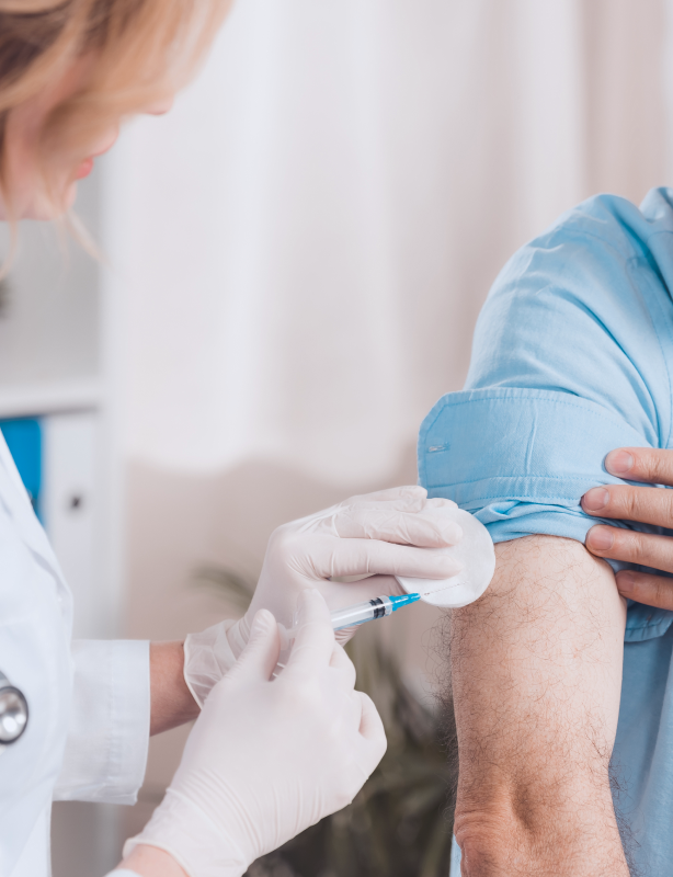 Hombre recibiendo una vacuna en el brazo.