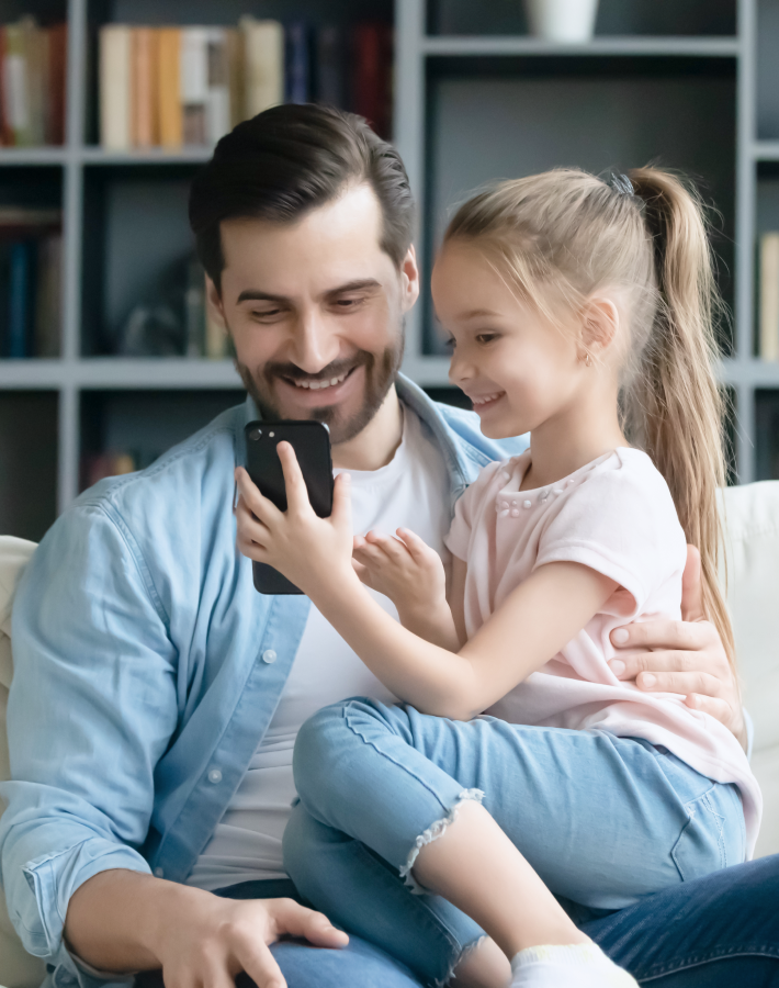 Padre e hija jugando con el móvil.