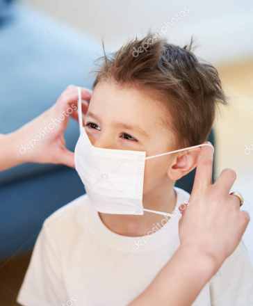 Persona poniendo mascarilla a niño