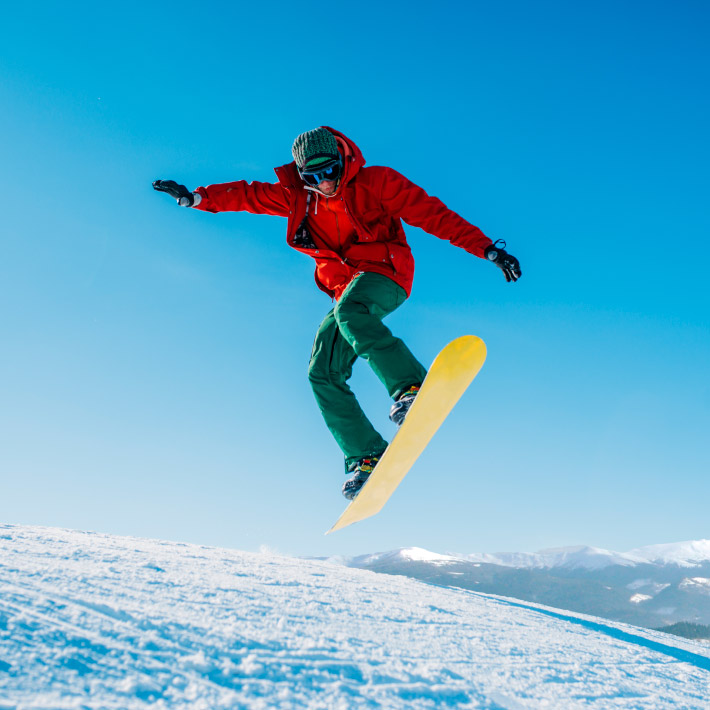 Jóven en un salto de snowboard.